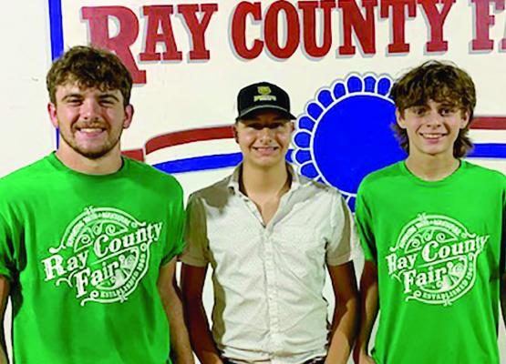 Orrick FFA members Tucker Greer, Cash Honeycutt, and Logan Smith participating in the Ray Co Fair Swine Show and premium auction.