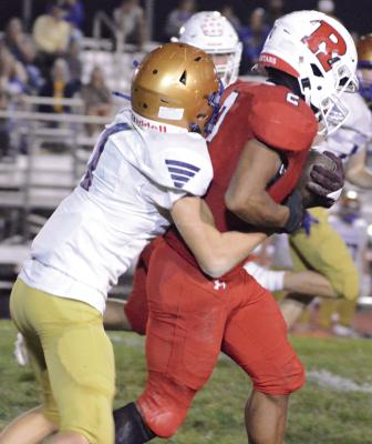 RICHMOND SENIOR Cyrus Jackson (right) fights through the grasp of would-be tackler Xavier Myers during his second-half kickoff return to help the Spartans rout rival Lafayette County of Higginsville. SHAWN RONEY | Staff