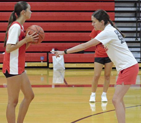 BRYLEE CASTILLEJA (left) and Richmond varsity girls basketball coach Kaylee Vantrump help demonstrate a drill during an offseason camp session. SHAWN RONEY | Staff