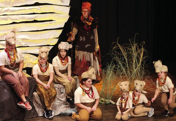 SOPHIA BALES | Staff LIONESSES ABIGAIL GARLAND (from left), Anna Garland, Kaeleigh Damron, Isbella Hendley, Gray McBee, Addison Garland and Margot Wiggins sing as Avis Rodenberg (standing) plays Rafiki in the musical.
