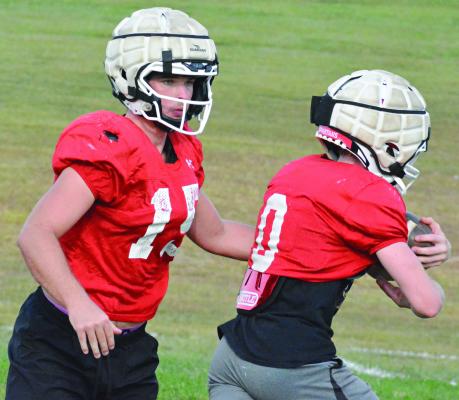 A FEW DAYS after being part of a wild win over Marshall, Richmond quarterback Jacob Lieberknecht (left) hands off to Nolan Quick as the Spartans prepare to host Center, a Kansas City-based school, for homecoming. SHAWN RONEY | Staff
