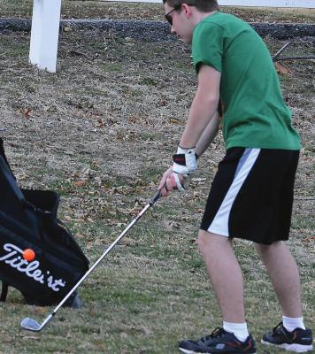 ACCEPTING THE challenge of playing golf, Orrick first-year high schooler Jeffrey Singleton attempts a chip shot March 17 at the Excelsior Springs Golf Course. SHAWN RONEY | Staff