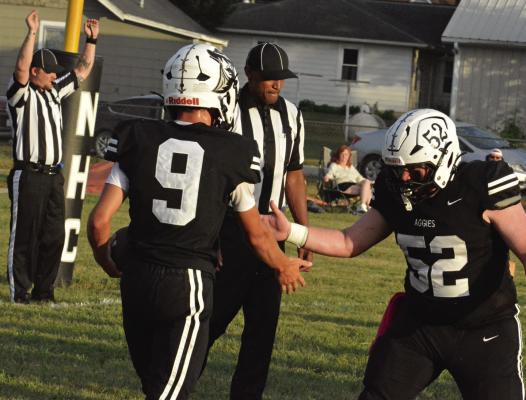 AN OFFICIAL (left) signals a touchdown as Brody Fifer (center) celebrates with Noborne Hardin-Central teammate Jace McNelly following a first-quarter score. SHAWN RONEY | Staff