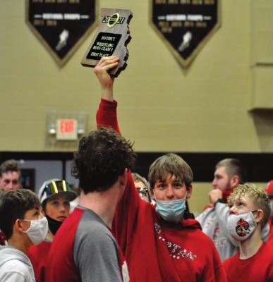 SENIOR RYKER PLYMELL hoists the Class 1 District 6 plaque after he and his fellow Spartans win the team title at Lathrop. SHAWN RONEY | Staff