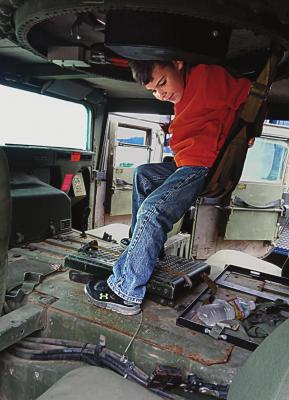 INSIDE the Ray County Sheriff’s Office military surplus MRAP vehicle, Joseph Kinnison, 6, sits in the cloth seat under the turret. SHARON DONAT | Staff affiliate