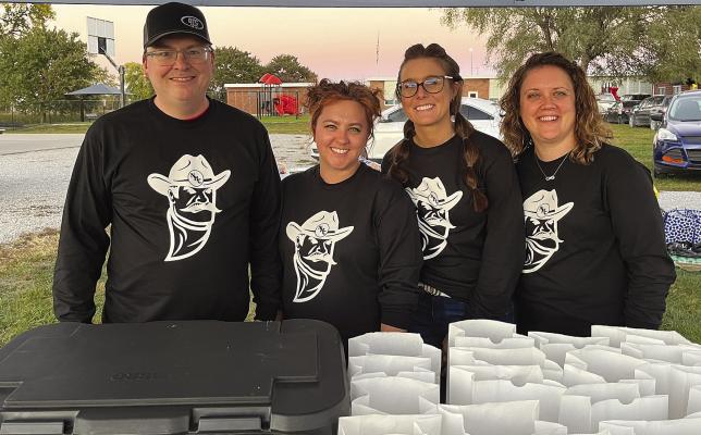BTC BANK staffers and participants Jason Frazer (from left), Megan Armstrong, Jenna Miller and Tesha Buhrmeister serve $5 meals at the Hardin-Central game last week. SOPHIA BALES | Staff