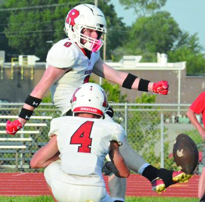 NOLAN QUICK hits the football squarely while kicking an extra point for the White Team, with Latimer Cavanah serving as his holder.