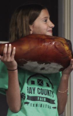EMEREE BARHAM holds her cured ham entry for the crowd. SHARON DONAT | Staff