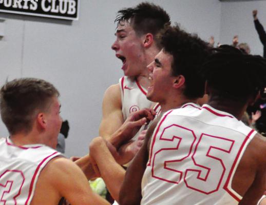 THE SPARTANS mob senior Wyatt Covey, center, after his game-winning steal and layup Monday night against visiting Knob Nobster. Junior Layne Cavanah leaps beside him. SHAWN RONEY | Staff