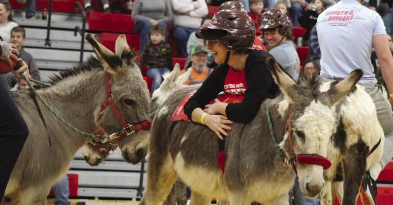 SHARON DONAT | Staff HIGH SCHOOL TEACHER Jennifer Clark takes a break with her donkey during the Richmond FFA donkey basketball fundraiser.
