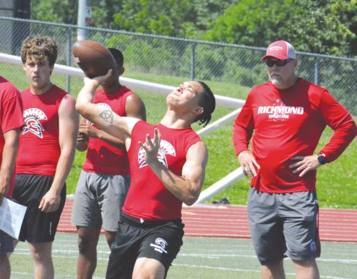 WITH COACHES and teammates standing by, Richmond quarterback Donivin Williams heaves a pass during 7-on-7 action Tuesday morning at Kearney High School. SHAWN RONEY | Staff