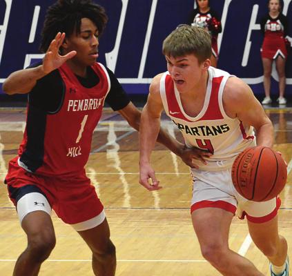 CLOSELY GUARDED, Richmond junior Eli Steele tries to go left against Pembroke Hill junior Devin Conley during the first quarter of the Spartans’ 52-32 season-ending loss March 12 in the Class 4 state quarterfinals at Blue Springs. SHAWN RONEY | Staff