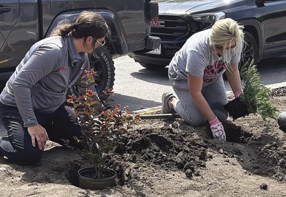 PARKS AND RECREATION Department Assistant Mindy Todd (left) and Director Hailey Williams plant flowers at Hamann Park for Earth Day. KAITLYN RIDDLE | Staff