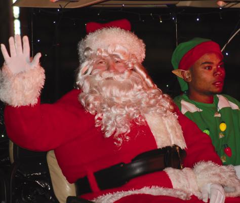 SANTA AND a North Pole elf make way in the parade.
