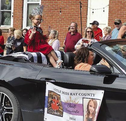 LITTLE MISS RAY COUNTY Charli Dunwoodie waves at the crowd during the Mushroom Festival parade. KAITLYN RIDDLE | Staff