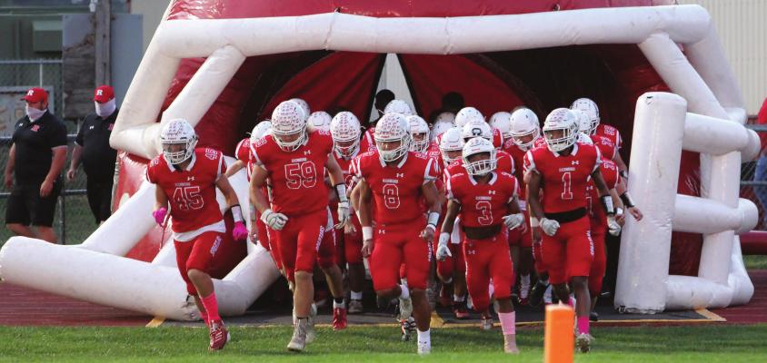 RICHMOND quarterback Keyshaun Elliott, No. 8, leads far fewer teammates onto the field after 26 Spartans are sidelined to undergo COVID-19 testing.