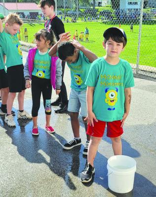 QUAID EDELBROCK (from left), Kenia Lopez and Quinton Gilmore line up behind Manny Martinez to start the water relay while helper Rylen Boyd keeps order. DIANA SHULL | Staff