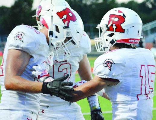 JOSH PYLE, No. 15, is congratulated by teammates Thomas Murphy, left, and Hunter Bowman after his interception Sept. 2 at Oak Grove. SHAWN RONEY | Staff