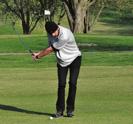 ORRICK SENIOR Dylan Comstock keeps his eye on the ball as he attempts an iron shot Monday at Shirkey Golf Course. SHAWN RONEY | Staff