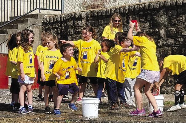 MRS. ASHLEY CRAMER’S class, named “Cramer’s Critters,” splash around during the water relay race. DIANA SHULL | Staff