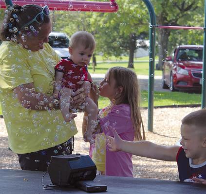 KELLY RARDON (from left), Stetson Basket, Journey Cameron and Hunter Williams enjoy the Bubbles in the Park event hosted by CAP. SHARON DONAT | Staff