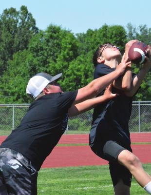 TRYCE McCOY, right, intercepts a pass June 2 at Spartan Stadium during a two-hand touch football scrimmage to help cap the Future Spartan Football Camp, offered to grades K-6. SHAWN RONEY | Staff