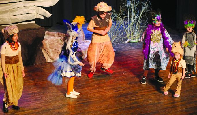 ELIJAH DURHAM (middle, from left) and QUINNLEY LAWSON play Simba and Zazu, respectively, as they dance around the stage during scene five, “I Just Can’t Wait to be King” song.