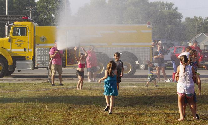 ORRICK FIRE DEPARTMENT volunteers spray children with hoses. MIRANDA JAMISON | Staff