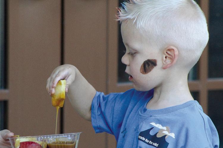 LENNOX BELL enjoys the classic combination of apples and caramel at the Oak Ridge Fall Festival. SHARON DONAT | Staff