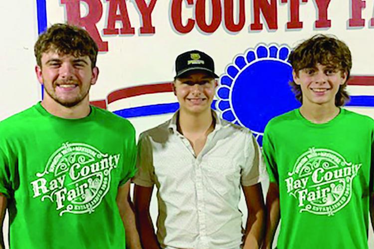 Orrick FFA members Tucker Greer, Cash Honeycutt, and Logan Smith participating in the Ray Co Fair Swine Show and premium auction.