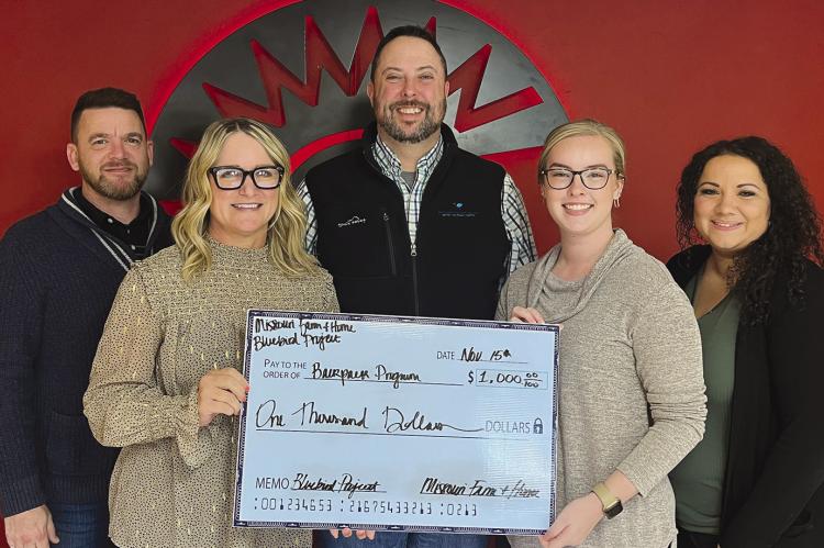 BLUEBIRD PROJECT members Mark McFee (from left), Amy Wirsig, Jimmy Carter, and Julia Landers gift a $1,000 check to Richmond R-XVI School District. Secretary Nicole Yoakum (far right) accepted the check on behalf of the district. SOPHIA BALES | Staff