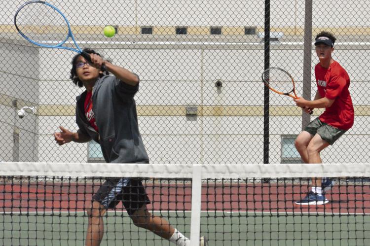 DARIUS MAYLON of Richmond (left) looks to hit a volley at the net in districts, with doubles partner Jazspher Ulleberg watching from behind the baseline. SHAWN RONEY | Staff