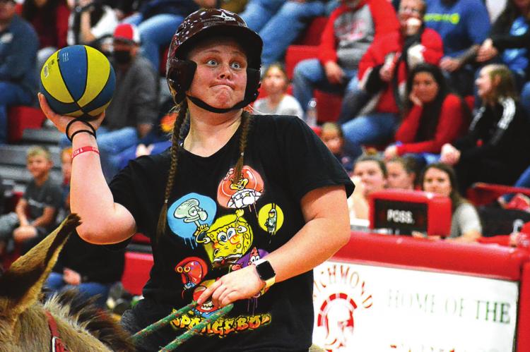 SENIOR LEXI BOKARAE, a three-sport athlete, tries her hand at donkey basketball March 21 in the Richmond High School Gym. SHAWN RONEY | Staff