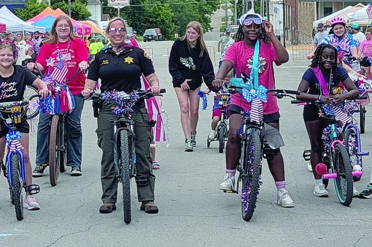 CHILDREN AND FAMILIES pedal decorated bicycles through downtown Richmond while judges assess entries in various categories during the America 250th Celebration. Participants decorated their bikes with patriotic ornaments before traveling the route. MIRANDA JAMISON | Staff