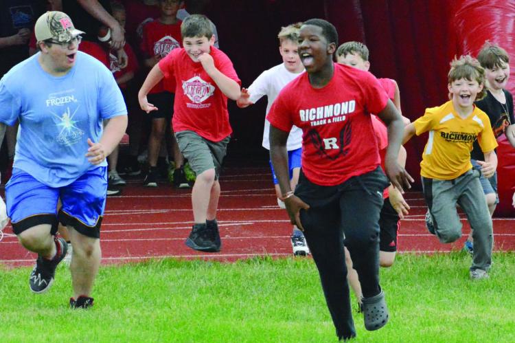 SEBASTIAN SVEISTRUP (front, left) and Savion Webb lead some youngsters through an inflated tunnel onto Tom Adams Field at Spartan Stadium on the final day of Richmond’s two-day youth football camp, overseen by Richmond varsity football coach Nick Persell. Look for additional coverage May 30. SHAWN RONEY | Staff