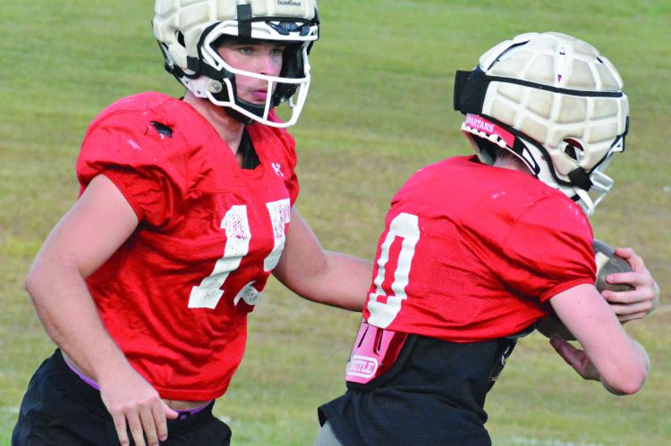 A FEW DAYS after being part of a wild win over Marshall, Richmond quarterback Jacob Lieberknecht (left) hands off to Nolan Quick as the Spartans prepare to host Center, a Kansas City-based school, for homecoming. SHAWN RONEY | Staff