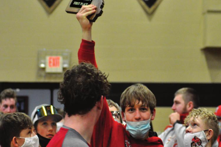 SENIOR RYKER PLYMELL hoists the Class 1 District 6 plaque after he and his fellow Spartans win the team title at Lathrop. SHAWN RONEY | Staff