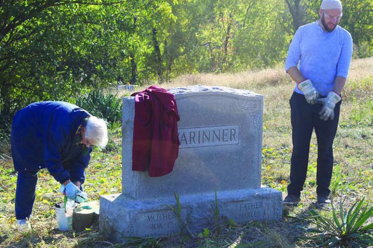 KAY BARCHERS (left) applies herbicide to freshly cut tree stump with James Evans.