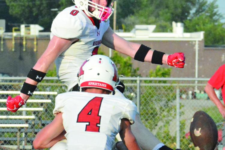 NOLAN QUICK hits the football squarely while kicking an extra point for the White Team, with Latimer Cavanah serving as his holder.