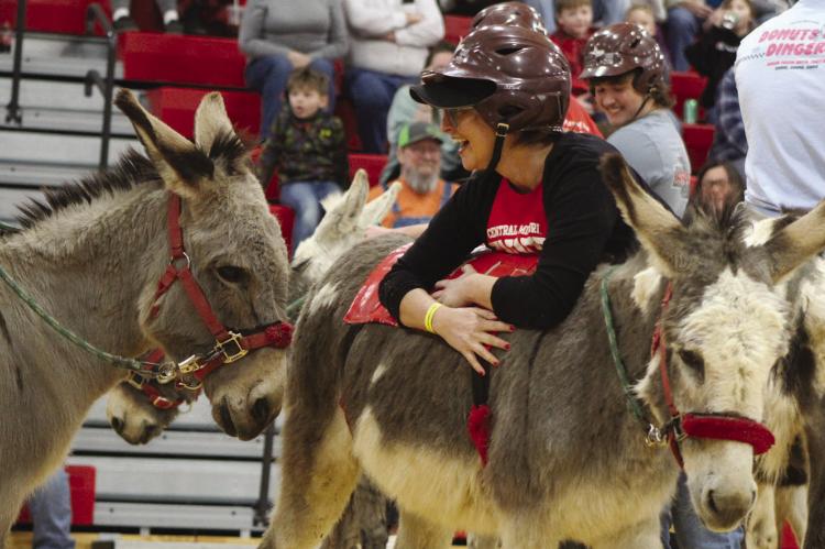SHARON DONAT | Staff HIGH SCHOOL TEACHER Jennifer Clark takes a break with her donkey during the Richmond FFA donkey basketball fundraiser.