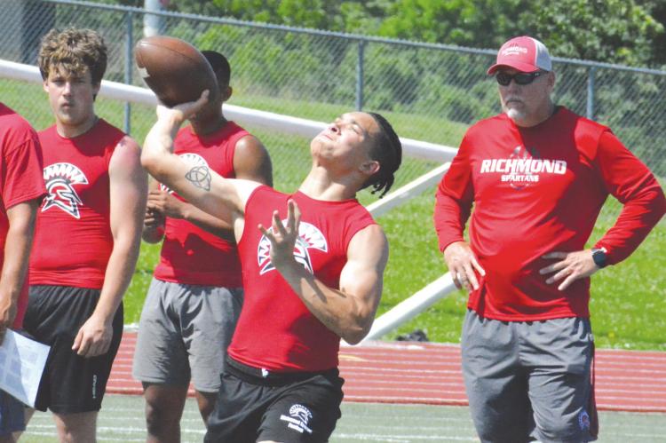 WITH COACHES and teammates standing by, Richmond quarterback Donivin Williams heaves a pass during 7-on-7 action Tuesday morning at Kearney High School. SHAWN RONEY | Staff
