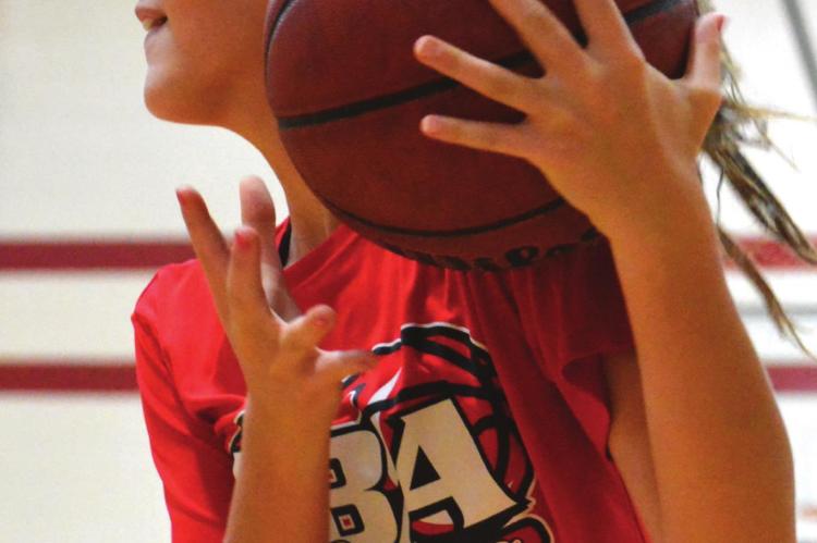 RICHMOND MIDDLE SCHOOLER Adilyn Swope collects a rebound after a missed shot and looks toward the hoop Monday during basketball camp. SHAWN RONEY | Staff