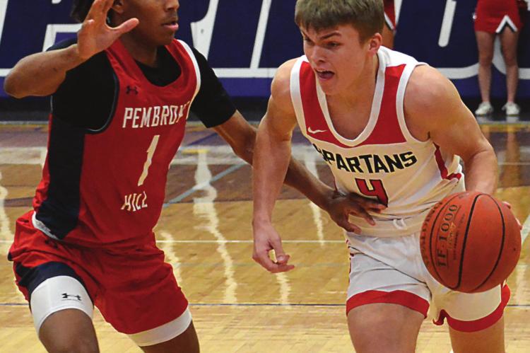 CLOSELY GUARDED, Richmond junior Eli Steele tries to go left against Pembroke Hill junior Devin Conley during the first quarter of the Spartans’ 52-32 season-ending loss March 12 in the Class 4 state quarterfinals at Blue Springs. SHAWN RONEY | Staff