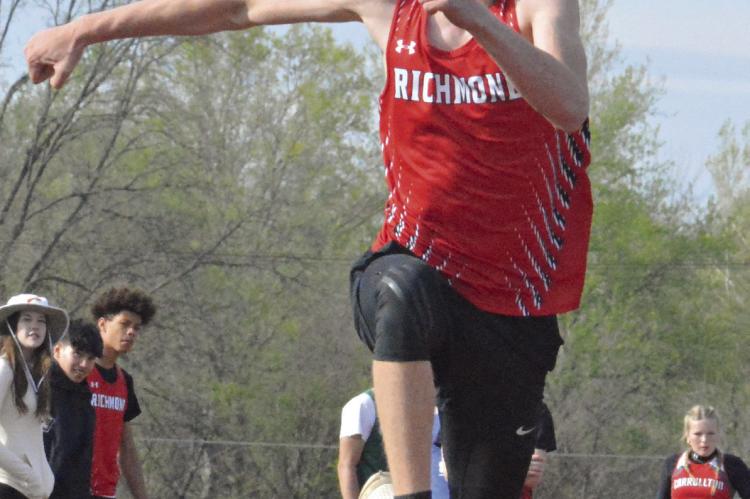 WITH ONLOOKERS nearby, Jacob Johnson extends his right arm as he goes airborne while competing in the boys triple jump at the Bruce Finlayson Invitational April 19 at Carrollton. Johnson wins the event and the long jump. SHAWN RONEY | Staff