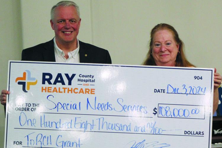 RAY COUNTY HOSPITAL and Healthcare CEO Jeff Bloemaker (left) presents a $108,000 check to SNS Executive Director Suzan Breen to help fund the new program. SHARON DONAT | Staff