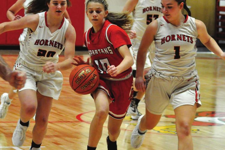 THE HORNETS display the defensive skills that make them the kind of ballclub the Spartans want to be. The Hornets swarm around Richmond freshman Kaylee Pugh on Tuesday in Lawson Invitational play. SHAWN RONEY | Staff
