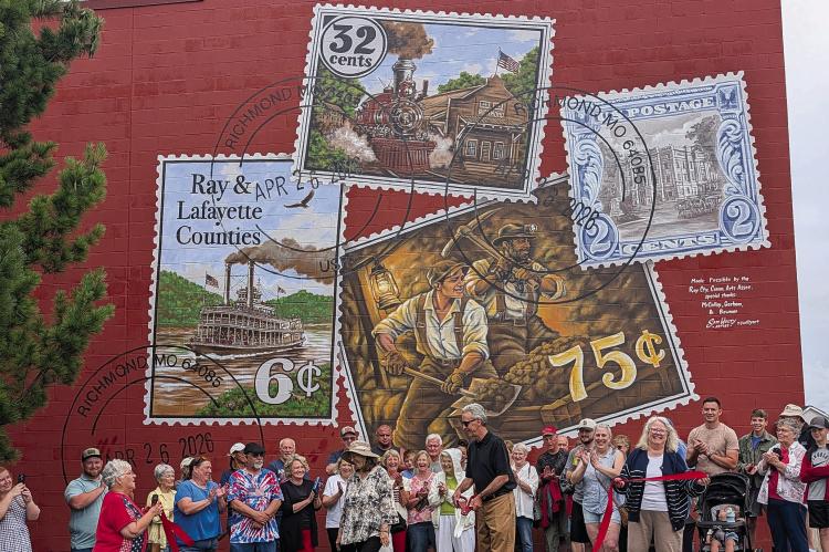 COMMUNITY MEMBERS celebrate the completion of a new mural at 206 West Main Street. The artwork brings together scenes from the community’s past while honoring the people and traditions that continue to define the city. MIRANDA JAMISON | Staff