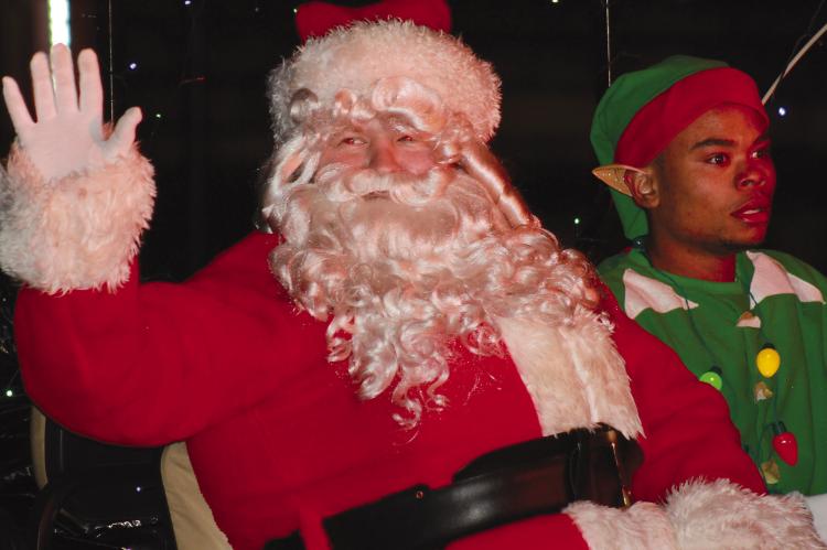 SANTA AND a North Pole elf make way in the parade.