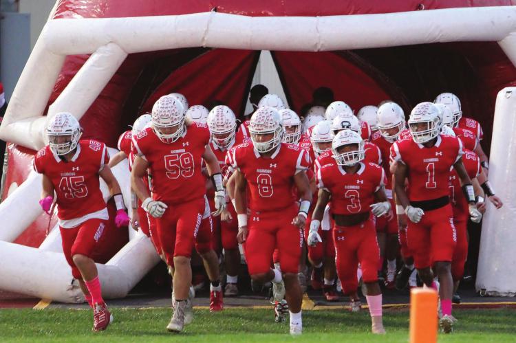 RICHMOND quarterback Keyshaun Elliott, No. 8, leads far fewer teammates onto the field after 26 Spartans are sidelined to undergo COVID-19 testing.