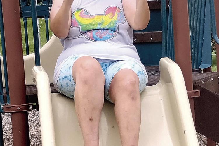 CONSTANCE ARNOLD takes a break from fishing for a turn on the slide.